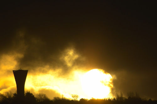 photo de lever de soleil à côté d'un château d'eau