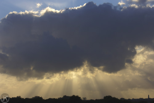 soleil caché par un nuage qui laisse passer les rayons